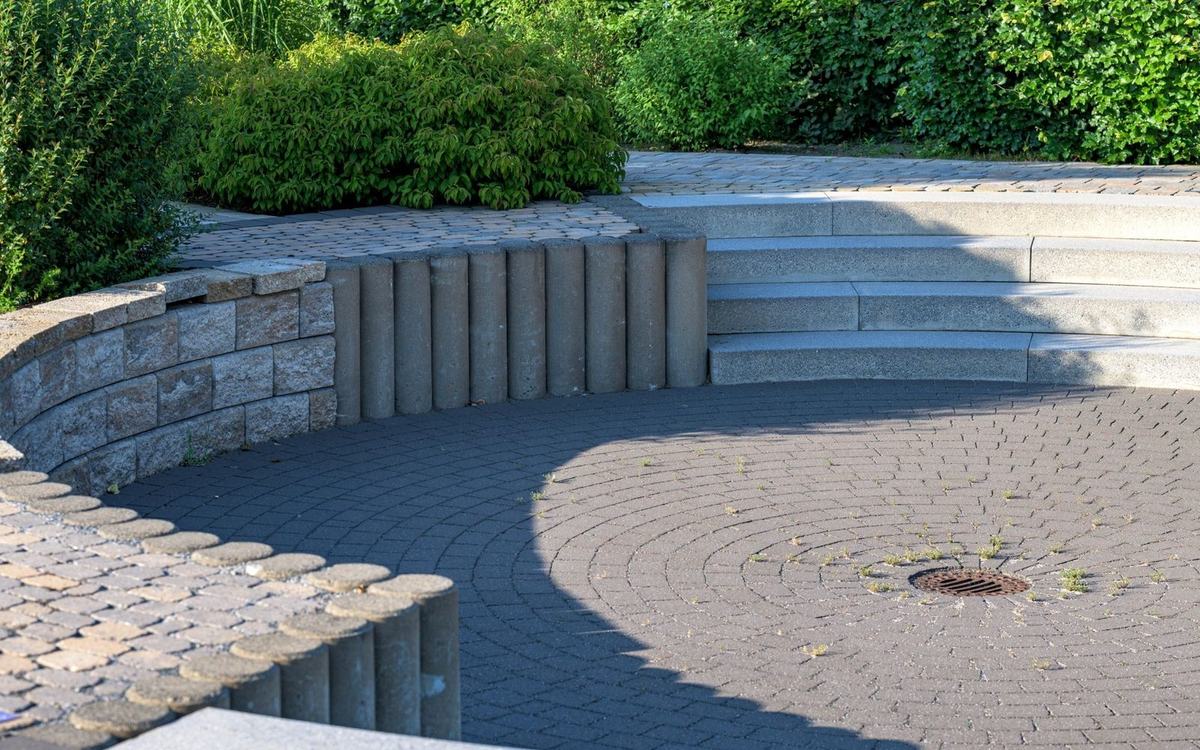 Stone paved garden area with steps and a low retaining wall